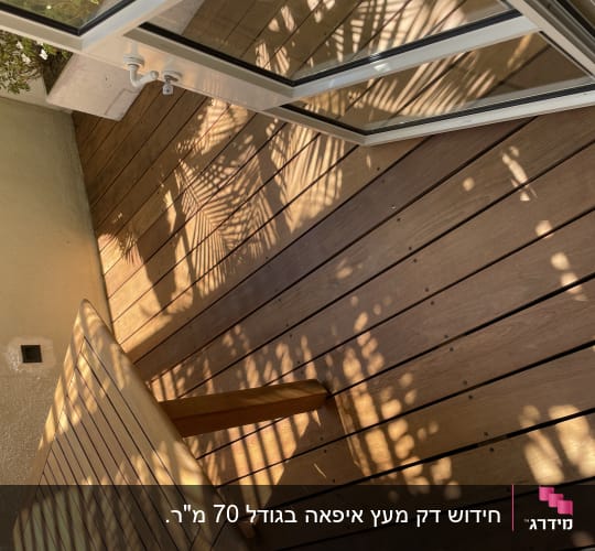 רצפת עץ עם צללים של צמחים ופתיחת דלת זכוכית